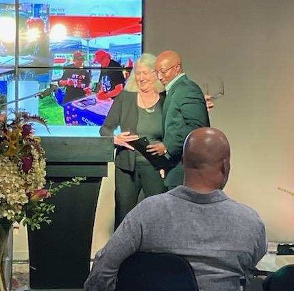 Restored voter Joe Bennett receiving an award from RMV co-director Dori Miles at GBM's celebration of restored voters