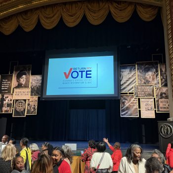 RMV Sponsors the Ida B. Wells Humanitarian Awards Ceremony Return My Vote logo on screen at the Davis Theatre during the Ida B. Wells Humanitarian Awards Ceremony